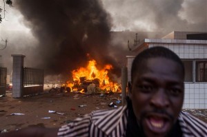 A car burns outside the parliament building in Burkina Faso as people protest against their longtime president Blaise Compaore who is seeking another term in Ouagadougou, Burkina Faso, Thursday, Oct. 30, 2014. AP