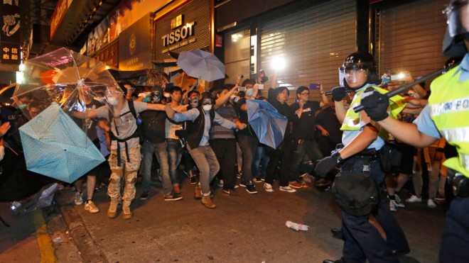 Protesters confront riot police in the occupied area in the Mong Kok district of Hong Kong, early Saturday, Oct. 18, 2014. New scuffles broke out Friday night between Hong Kong riot police and pro-democracy activists in a district where police cleared protesters earlier in the day. (AP Photo/Kin Cheung)