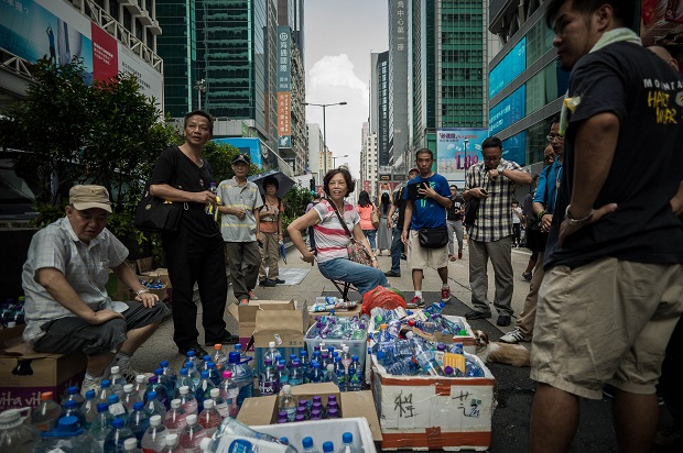 Supporters of pro-democracy demonstrators provide free drinking water in the Mongkok district of Hong Kong on September 30, 2014. Tens of thousands of pro-democracy protesters turned parts of Hong Kong into a massive street party on September 29 night, with the mood turning festive just a day after riot police fired tear gas in ugly clashes. AFP PHOTO / Philippe Lopez
