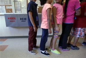 In this Sept. 10, 2014 file photo, detained immigrant children line up in the cafeteria at the  Karnes County Residential Center,  a temporary home for immigrant women and children detained at the border, in Karnes City, Texas. AP