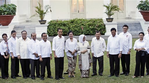 From left, Indonesian Maritime and Fisheries Minister Susi Pudjiastuti, Transportation Minister Ignasius Jonan, Coordinating Minister for Maritime Affairs Indroyono Susilo, National Development Planning Minister Andrinof Chaniago, State Secretary Pratikno, Indonesian President Joko Widodo, his wife Iriana, Vice President Jusuf Kalla's wife Mufidhah, Vice President Jusuf Kalla, Coordinating Minister for Security Tedjo Edhy Purdijatno, Home Affairs Minister Tjahjo Kumolo, and Foreign Minister Retno Marsudi pose for photographers during the announcement of the new cabinet at the presidential palace in Jakarta, Indonesia, Sunday, Oct. 26, 2014. Indonesia's new president unveiled his Cabinet on Sunday, a compromise lineup featuring technocrats in key finance roles who will need to push painful reforms to fix the country's slowing economy, but also including politicians who supported his spectacular rise to power.  AP PHOTO/ACHMAD IBRAHIM