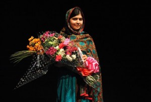 Malala Yousafzai poses with a bouquet after speaking during a media conference at the Library of Birmingham, in Birmingham, England, Friday, Oct. 10, 2014, after she was named as winner of The Nobel Peace Prize. AP
