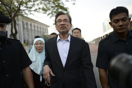 Malaysian opposition leader Anwar Ibrahim, center, walks with his wife Wan Azizah as they arrive for his final hearing of his sodomy conviction in Putrajaya, Malaysia, Tuesday, Oct. 28, 2014.  AP