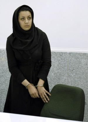 A picture taken on July 8, 2007 shows Iranian Reyhaneh Jabbari standing handcuffed at police headquarters in Tehran after she was arrested for the murder of a former intelligence official. Jabbari who is awaiting an impending death sentence for slaying of former intelligence official Morteza Abdolali Sarbandi, could be forgiven if "she tells the truth", the victim's son said on April 19, 2014 as a UN human rights monitor claims the crime was done in self-defence against a potential rapist.   AFP PHOTO/GOLARA SAJADIAN