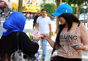 An electoral volunteer, right, distributes leaflets, Friday, Oct. 24, 2014, to encourage the public to vote on the iconic Bourguiba Avenue which witnessed the culmination of Tunisia’s revolution against dictator Zine El Abidine Ben Ali in 2011, in Tunis, Tunisia. AP
