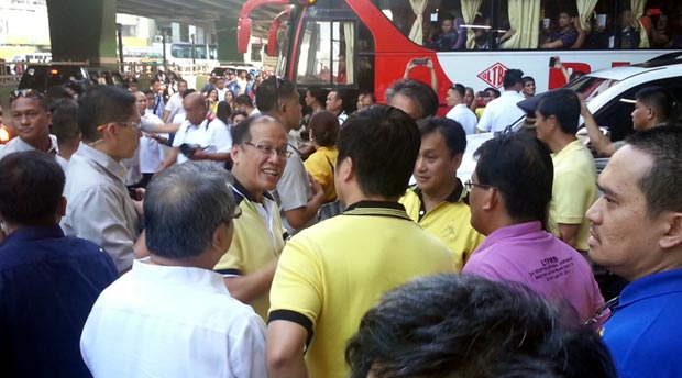 Aquino gives away rubber wrist bands to the province-bound passengers at a bus terminal along Buendia Avenue, Makati. MATIKAS SANTOS/INQUIRER.net