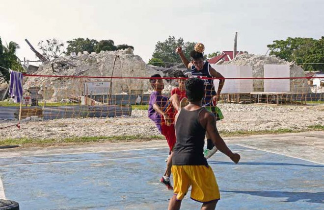 BOUNCING BACK These young men enjoy playing “sepak takraw” near the ruined Our Lady of the Light Church in Loon town, Bohol province, a year after a 7.2-magnitude earthquake destroyed parts of the town. LITO TECSON/CEBU DAILY NEWS