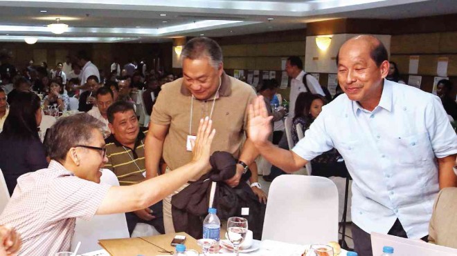 ROXAS and fellow Liberal Party stalwart Budget Secretary Florencio Abad give each other high fives at a conference on good governance in Cebu City. In their middle is Cebu Gov. Hilario Davide III, also a Liberal Party loyalist. JUNJIE MENDOZA/CEBU DAILY NEWS 