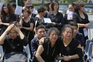 In this June 21, 2014 photo, relatives cry during a funeral for workers who died following a Dec. 1, 2013 fire in a Chinese-run textile factory in Prato, Italy. AP