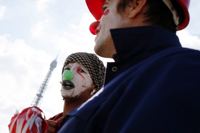 People, dressed as clowns, take part in a demonstration against the exploitation of schist gazes and oils on September 22, 2012, on the Trocadero square in Paris. A 14-year-old dressed as a clown was arrested Monday, Oct. 27, 2014, near Paris for attempting to attack a woman, as a strange phenomenon of fake, evil clowns terrorizing passersby spreads in France.  AFP PHOTO KENZO TRIBOUILLARD