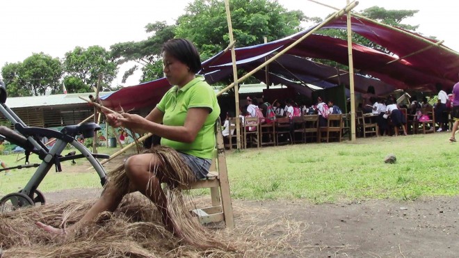 LIFE GOES ON  A woman finds comfort in making handicraft products while classes go on at an evacuation center in Camalig town, Albay province. MICHAEL B. JAUCIAN 