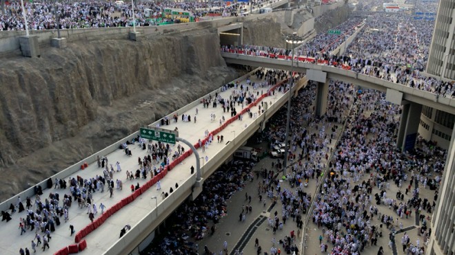 In this Sunday, Oct. 5, 2014 photo, thousands of Muslim pilgrims make their way to throw stones at a pillar, symbolizing the stoning of Satan during the annual pilgrimage, known as the hajj, outside of Mecca, Saudi Arabia. The roughly five-day hajj is meant to cleanse the faithful of sin and required of all able-bodied Muslims to perform once in their lives. Though pilgrims will repeat the stoning ritual for two days, they can now be referred to as "hajjis," a term of honor for completing the pilgrimage. (AP Photo/Khalid Mohammed)