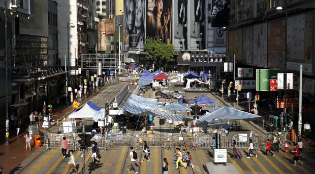Students walk past barricades on a main road in the occupied areas at Causeway Bay district in Hong Kong, Friday, Oct. 10, 2014. A pro-democracy protest that has blocked main roads in Hong Kong for almost two weeks could drag on for days yet, after talks aimed at resolving a bitter standoff between the city's government and student demonstrators collapsed Thursday. AP