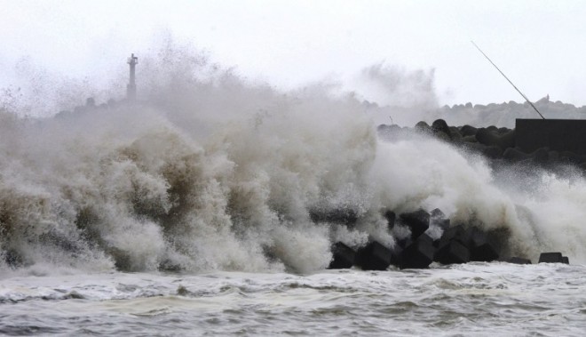 High waves batter a breakwater at a port of Kawaminami town in Miyazaki prefecture, Japan's southern island of Kyushu on Monday, Oct. 13, 2014. Powerful typhoon Vongfong barreled into Japan, with at least one person missing and dozens injured.  AFP PHOTO/JIJI PRESS 
