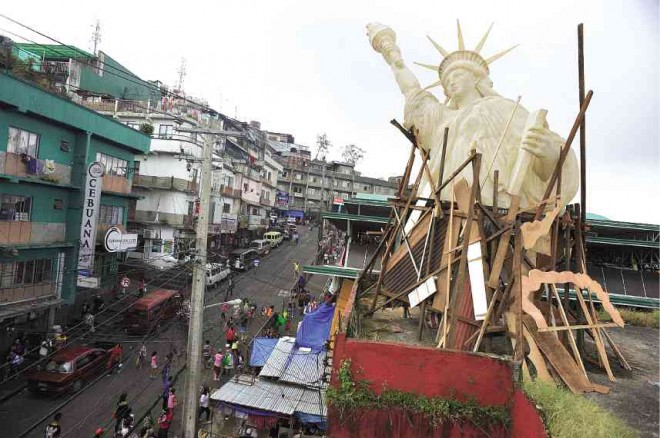 ARTISTS from Baguio City and Manila assembled pieces of installations and distributed these along  Baguio City Public Market, including this giant Statue of Liberty towering over Kayang Road. The artists are offering these pieces to anyone willing to barter with commodities of equal value, like sacks of rice and vegetables that the artists need in their daily lives. EV ESPIRITU/INQUIRER NORTHERN LUZON