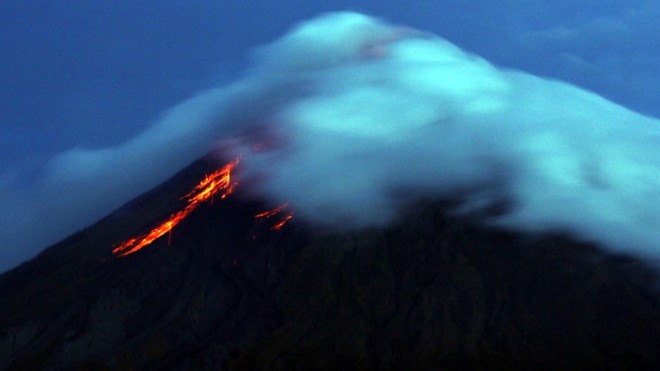 Lava flows from the crater of Mayon volcano seen from Legazpi City, Albay province, on Sept. 17, 2014. After evacuating about 55,000 people, Philippine authorities said Sunday, Oct. 5, they were laboring to move thousands of farm animals from areas threatened by the country's most active volcano.  AFP PHOTO/CHARISM SAYAT