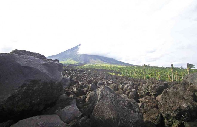 SMOKE from Mayon Volcano continues to paint an ominous picture with a picturesque backdrop as some villagers wait for the day they can leave government shelters to return to their normal lives. MARK ALVIC ESPLANA/INQUIRER SOUTHERN LUZON