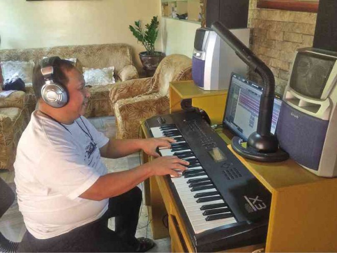 CESAR “Bong” Tongson composes and plays Pangasinan songs at his work station in his house in San Carlos City. GABRIEL CARDINOZA