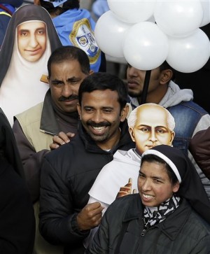 Cardboard cutouts of sister Eufrasia Eluvathingal, top left, and priest Elias Chavara, right, stand among Indian faithful at the end of their canonization Mass celebrated by Pope Francis in St. Peter's Square, at the Vatican, Sunday, Nov. 23, 2014.  AP PHOTO/GREGORIO BORGIA  