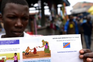 This file picture dated September 17, 2014  shows a man holding a Congolese Ministry of Health's information leaflet on Ebola virus on Moral's market in the Bandal area in Kinshasa. The Democratic Republic of Congo on November 15, 2014 declared itself Ebola-free, after a three-month outbreak of the killer disease claimed at least 49 lives. AFP/JUNIOR D. KANNAH