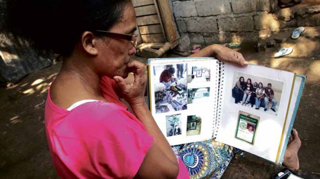 PHOTOGRAPHS AND MEMORIES CathyNuñez looks at photos of her son, Victor, who was one of 32 journalists killed in Ampatuan town,Maguindanao province, on Nov. 23, 2009. JB R. DEVEZA/INQUIRER MINDANAO