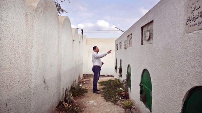 In this Wednesday, Nov. 5, 2014 file photo, Reda el-Danbouki, Egyptian lawyer for 13-year-old Sohair el-Batea who died undergoing the procedure of female genital mutilation committed by Dr. Raslan Fadl, points at her grave in Dierb Biqtaris village, on the outskirts of Aga town in Dakahliya,120 kilometers (75 miles) northeast of Cairo, Egypt. An Egyptian court on Thursday, Bov. 20, 2014 acquitted a doctor charged with committing female genital mutilation that led to the 13-year-old girl’s death in a Nile Delta village, a lawyer said. (AP Photo/Nariman El-Mofty)