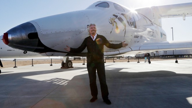In this Sept. 25, 2013, file photo, British entrepreneur Richard Branson poses with SpaceShipTwo at a Virgin Galactic hangar at Mojave Air and Space Port in Mojave, Calif. The Virgin Galactic's SpaceShipTwo space tourism rocket exploded Friday, Oct. 31, 2014, during a test flight, killing a pilot aboard and seriously injuring another while scattering wreckage in Southern California's Mojave Desert, witnesses and officials said. Virgin Galactic would not say what happened other than that it was working with authorities to determine the cause of the "accident." (AP Photo/Reed Saxon, File)