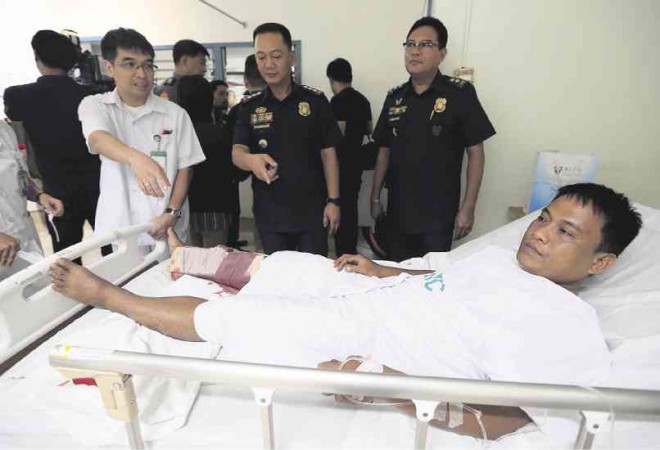 WOUNDED COP Police Officer 3 Armand Soliven relates to Quezon City police chief Senior Supt. Joel D. Pagdilao (center) and Supt. Nestor S. Abalos how he was wounded in pursuit of two snatchers in Barangay Tagumpay on Thursday morning. He was hit in the right leg and shoulder and underwent surgery at the Quirino Memorial Medical Center. LYN RILLON