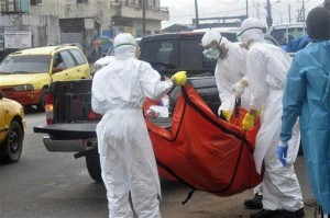 Health workers in protective gear carry the body of a person suspected to have died from Ebola on the street of Monrovia, Liberia. AP FILE PHOTO
