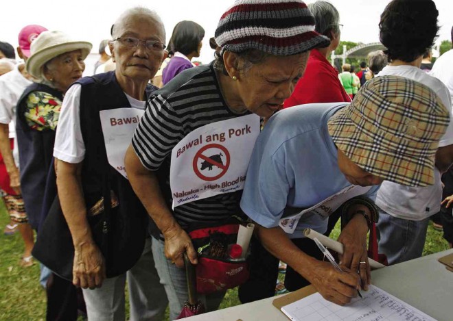 SENIOR citizens, during a rally in Manila, sign the people’s initiative to enact a law criminalizing the use of pork barrel funds in whatever form they take. RAFFY LERMA 
