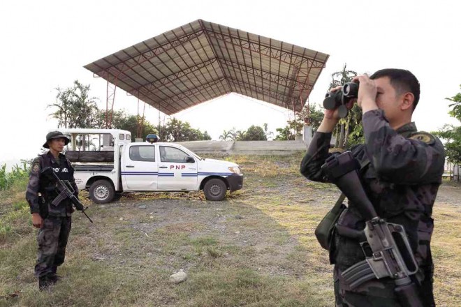 POLICEMEN secure the site where 58 people, including journalists, were slaughtered by followers and members of a political clan on Nov. 23, 2009, in Ampatuan town, Maguindanao province. JEOFFREY MAITEM/INQUIRER MINDANAO