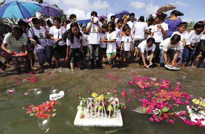 FAMILIES of victims of Supertyphoon “Yolanda” release flowers and candles out to sea to remember their loved ones at Barangay 88 in San Jose district, Tacloban City, after a Mass that commemorated the departed. RAFFY LERMA   