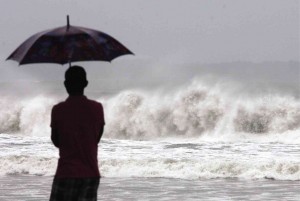 WAITING FOR ‘RUBY’ An anxious resident of Borongan City, Eastern Samar province, watches large waves slam into the shore as Eastern Visayas braces for the landfall of Typhoon “Ruby” in the area on Saturday. The country’s strongest typhoon this year made landfall hours later in Dolores town. RAFFY LERMA 