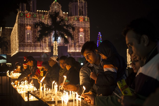 Indian Christians light candles at a Sacred Heart Cathedral on the eve of Christmas in New Delhi, India, Wednesday, Dec. 24, 2014.  Christmas is a national holiday in India, marked by millions of all religions and faiths. AP