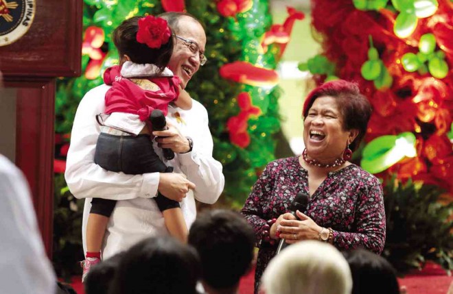  CHRISTMAS IS FOR CHILDREN In a playful mood, President Aquino carries a child during the Pasko ng Batang Pinoy gift-giving program at Malacañang on Friday.  With him is Social Welfare Secretary Corazon Soliman. GRIG C. MONTEGRANDE 