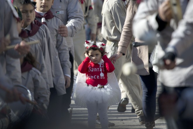 A Palestinian girl dressed in a costume joins a Christmas Eve celebration at Manger Square outside the Church of the Nativity, built atop the site where Christians believe Jesus was born, in the West Bank town of Bethlehem on Wednesday, Dec. 24, 2014. Christian pilgrims from around the world have begun to gather in the biblical town of Bethlehem for Christmas Eve celebrations in the traditional birthplace of Jesus. (AP Photo/Majdi Mohammed)