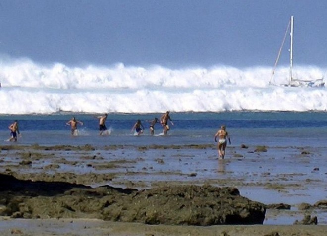 File photo dated 26 December 2004 shows tourists caught by the first of six tsunami rolling towards Hat Rai Lay Beach, near Krabi in southern Thailand. AP