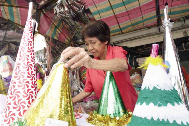 Carmen Vinoya minds her family’s torotot stall which has been a holiday fixture for the last 70 years on Gabriela Street, Tondo, Manila. NIÑO JESUS ORBETA