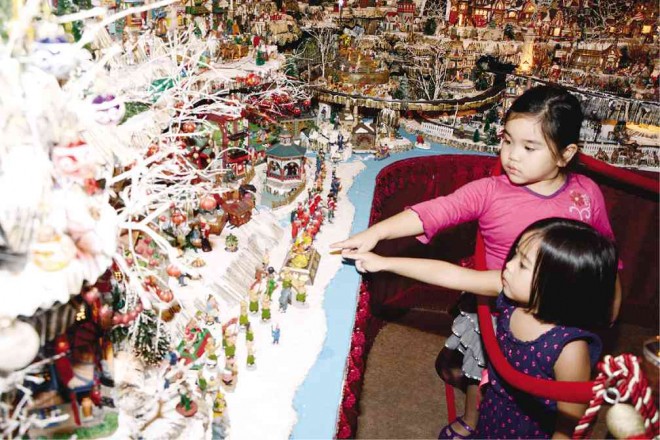 THE CHRISTMAS Village never fails to fascinate children like Denise Loyola and Zhye Tonogbanua who come and visit it. Philip Loyola/CONTRIBUTOR