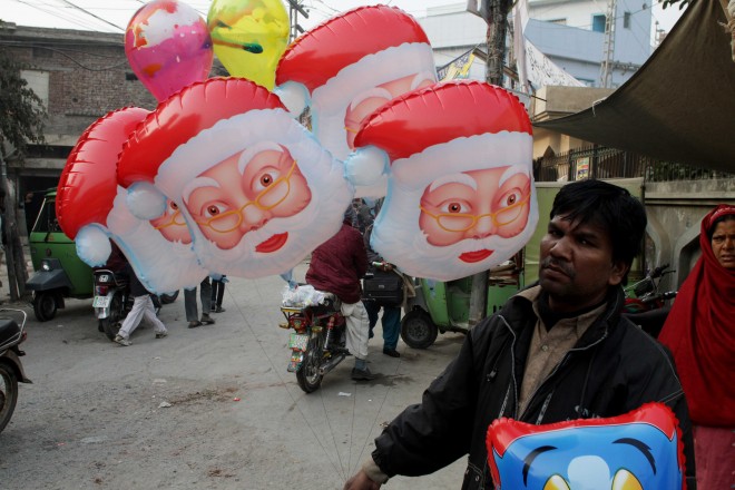 Pakistani vendor Maqbool Mashi sells Santa Claus balloons ahead of Christmas in Lahore, Pakistan, Wednesday, Dec. 24, 2014. (AP Photo/K.M. Chaudary)