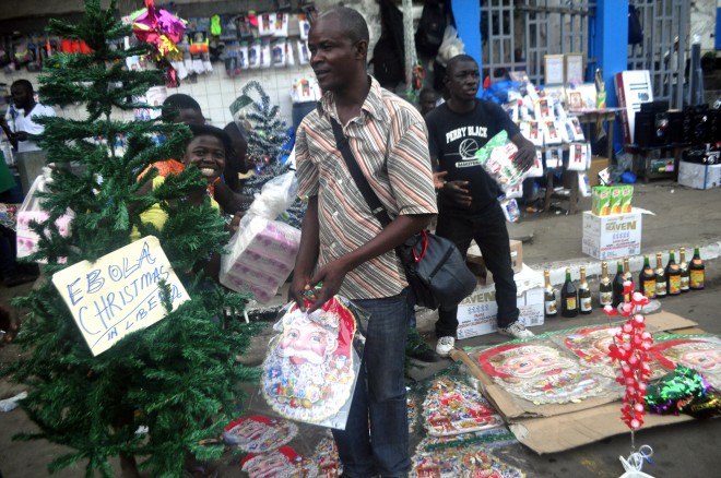 Liberian men shop for a Christmas tree at a shop in Monrovia, Liberia, Wednesday, Dec. 24, 2014. The deadly Ebola epidemic in Sierra Leone means no festive parties at the beach and no carolers singing at night. Authorities this year have banned any activities that could further the spread of the highly contagious virus now blamed for killing more than 7,000 people in West Africa over the past year. (AP Photo/Abbas Dulleh)