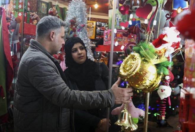 A woman shops for Christmas decoration items in central Baghdad, Iraq, Wednesday, Dec. 24, 2014. Although the number of Christians has dropped in Iraq, Christmas, a national holiday in Iraq, is very popular in the capital. (AP Photo/Karim Kadim)