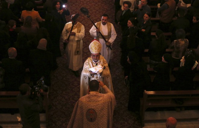 Iraqi Christians attend a Christmas Eve mass at Our Lady of Salvation in Baghdad, Iraq, Wednesday, Dec. 24, 2014. Iraqi Christians gathered for Christmas Eve services amid tight security. (AP Photo/Hadi Mizban)