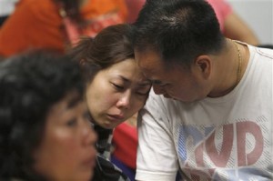 A relative of the passengers of AirAsia flight QZ8501 weeps as she waits for the latest news on the missing jetliner at a crisis center set up by local authority at Juanda International Airport in Surabaya, East Java, Indonesia, Sunday, Dec. 28, 2014. AP