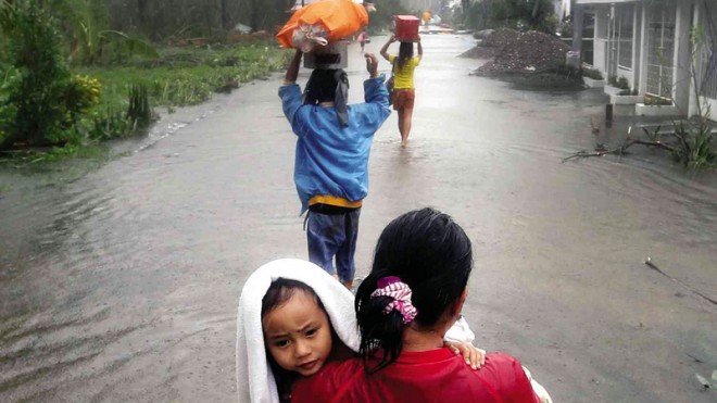 GOING HOME   Although the streets are still flooded, evacuees head for home in Borongan City, Eastern Samar, after Tropical Storm “Ruby” lashed the province. While tens of thousands return to their residences in the Visayas, many in areas like Batangas, Laguna and Cavite provinces and Metro Manila seek shelter in evacuation centers as Ruby crawls toward the West Philippine Sea.  RAFFY LERMA