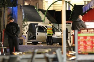 A police officer guards the van that crashed into a French Christmas market in Nantes, western France, Monday, Dec. 22, 2014. French authorities urged calm after a series of attacks across the country left dozens of people injured, and said there was no evidence the attacks were connected by any terrorist motive. AP