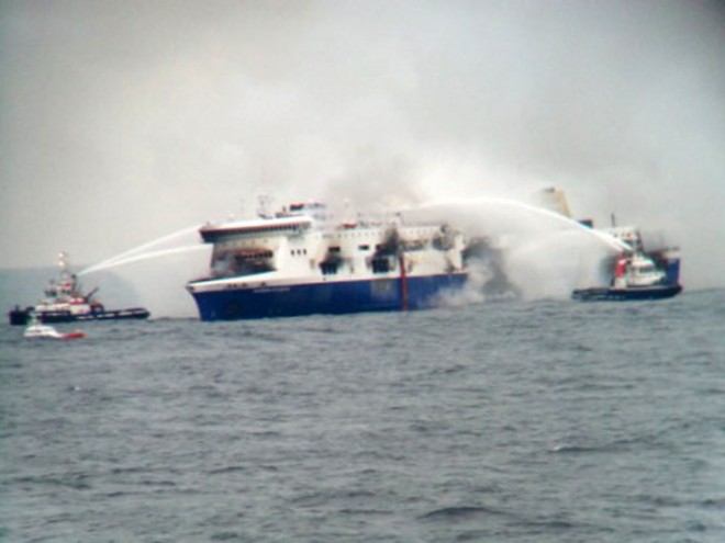 In this photo taken from a nearby ship, vessels try to extinguish the fire at the Italian-flagged Norman Atlantic after it caught fire in the Adriatic Sea, Sunday, Dec. 28, 2014. Italian and Greek military and coast guard rescue crews battled gale-force winds and massive waves Sunday as they struggled to rescue hundreds of people trapped on a burning ferry adrift between Italy and Albania.  AP PHOTO/SKAI TV STATION 