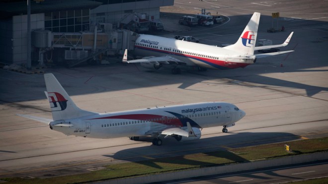 A Malaysia Airlines plane, foreground, leaves the the tarmac to take off at the Kuala Lumpur International Airport (KLIA) in Sepang, Malaysia, Friday, Nov. 28, 2014. Malaysia Airlines on Friday said its loss widened last quarter and apologized for a promotional tweet slammed as insensitive after two deadly passenger jet disasters this year. In its last public financial result before a planned privatization and overhaul, the flag carrier said its net loss in the July-September quarter rose 53 percent from a year earlier to 576.1 million ringgit ($170.3 million). (AP Photo/Vincent Thian)