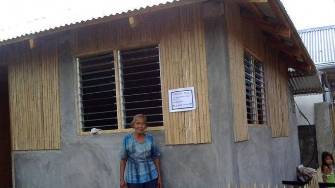 HOME ISWHERE HEART IS Marina Natividad in front of her new house, which UNHabitat helped build in Roxas City. The house, which has a four-sided roof and walls of concrete hollow blocks, can withstand powerful winds. PHOTO COURTESY OF UN HABITAT