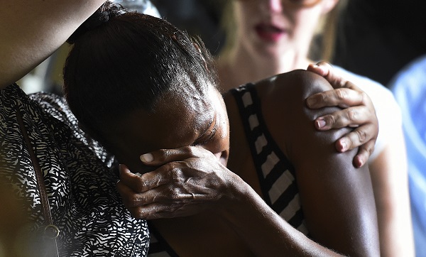 A woman cries  during a church service to remember eight children who were killed in the Cairns suburb of Manoora, Australia, Sunday, Dec. 21, 2014. Mersane Warria, 37, was charged with eight counts of murder in a bedside hearing at a hospital in the northern city of Cairns where she is recovering from stab wounds, Queensland state police said. AP